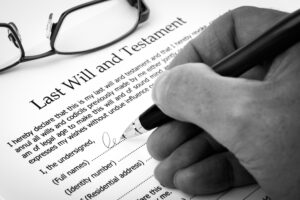 Estate Planning for Your Kids. Closeup of a hand signing a will in black & white. 
